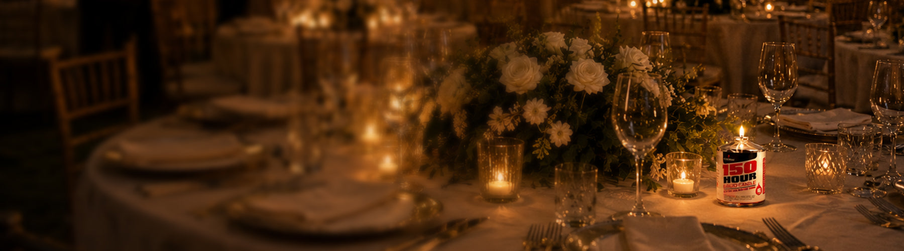 Dining table setup with candles and floral arrangements in a dimly lit room